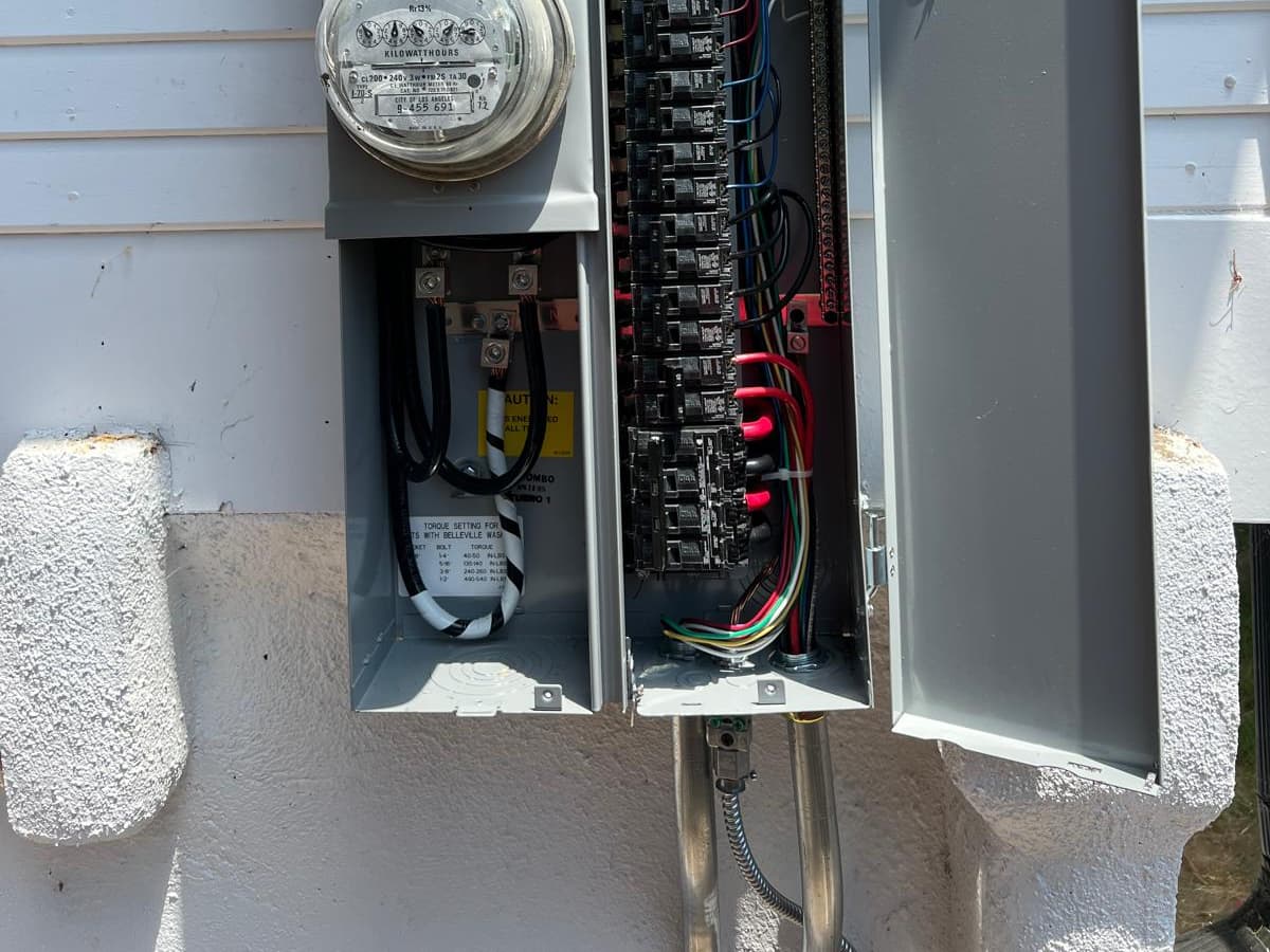 Completed electrical panel upgrade in Los Angeles by A+ Electric & Plumbing: new breaker panel and meter with clean, labeled wiring.