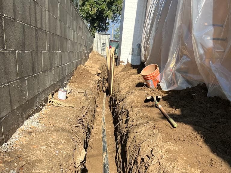New sewer line set in a side-yard trench by A+ Electric & Plumbing, licensed plumber in Los Angeles.