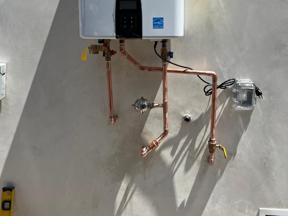 Tankless water heater installed in Los Angeles by A+ Electric & Plumbing: wall-mounted unit with new copper and gas lines.