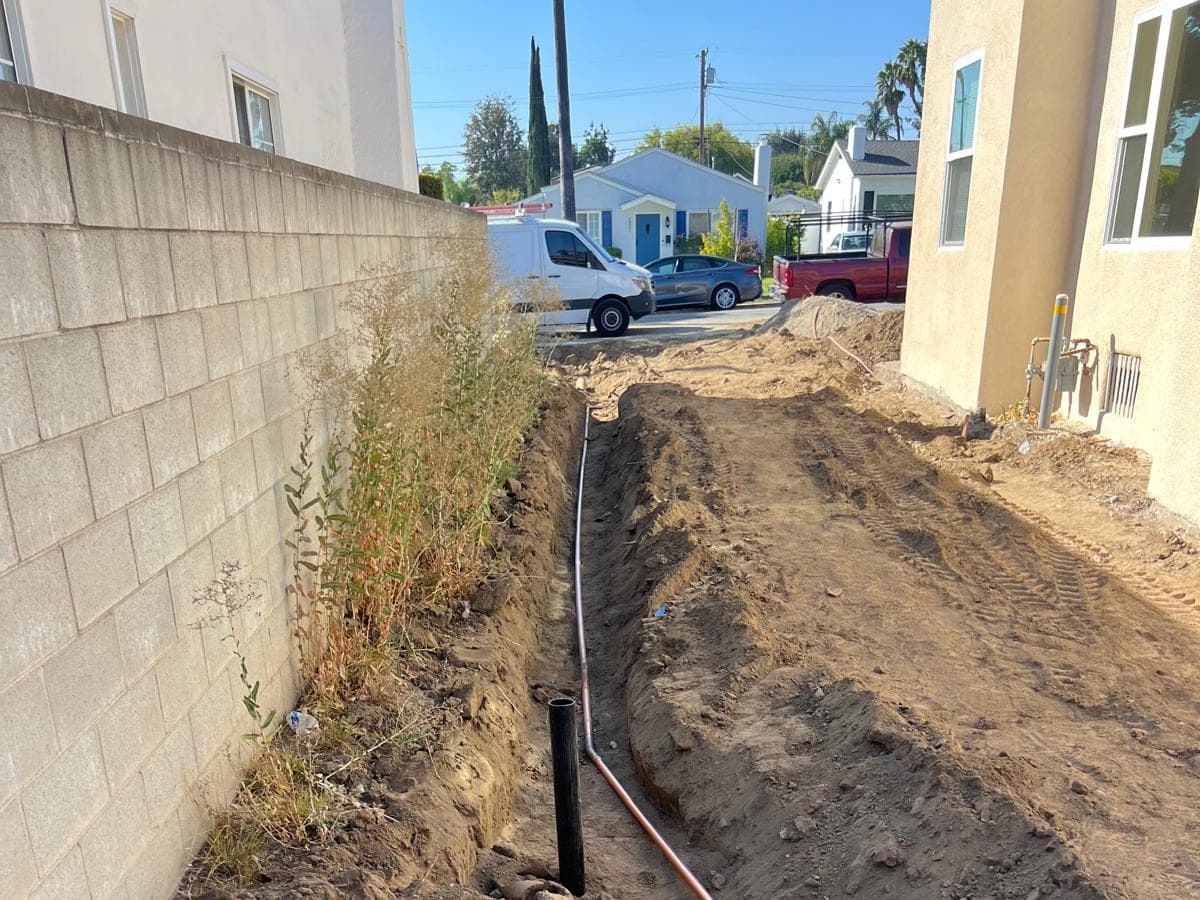 New copper water line in an open trench, installed by A+ Electric & Plumbing in Los Angeles.